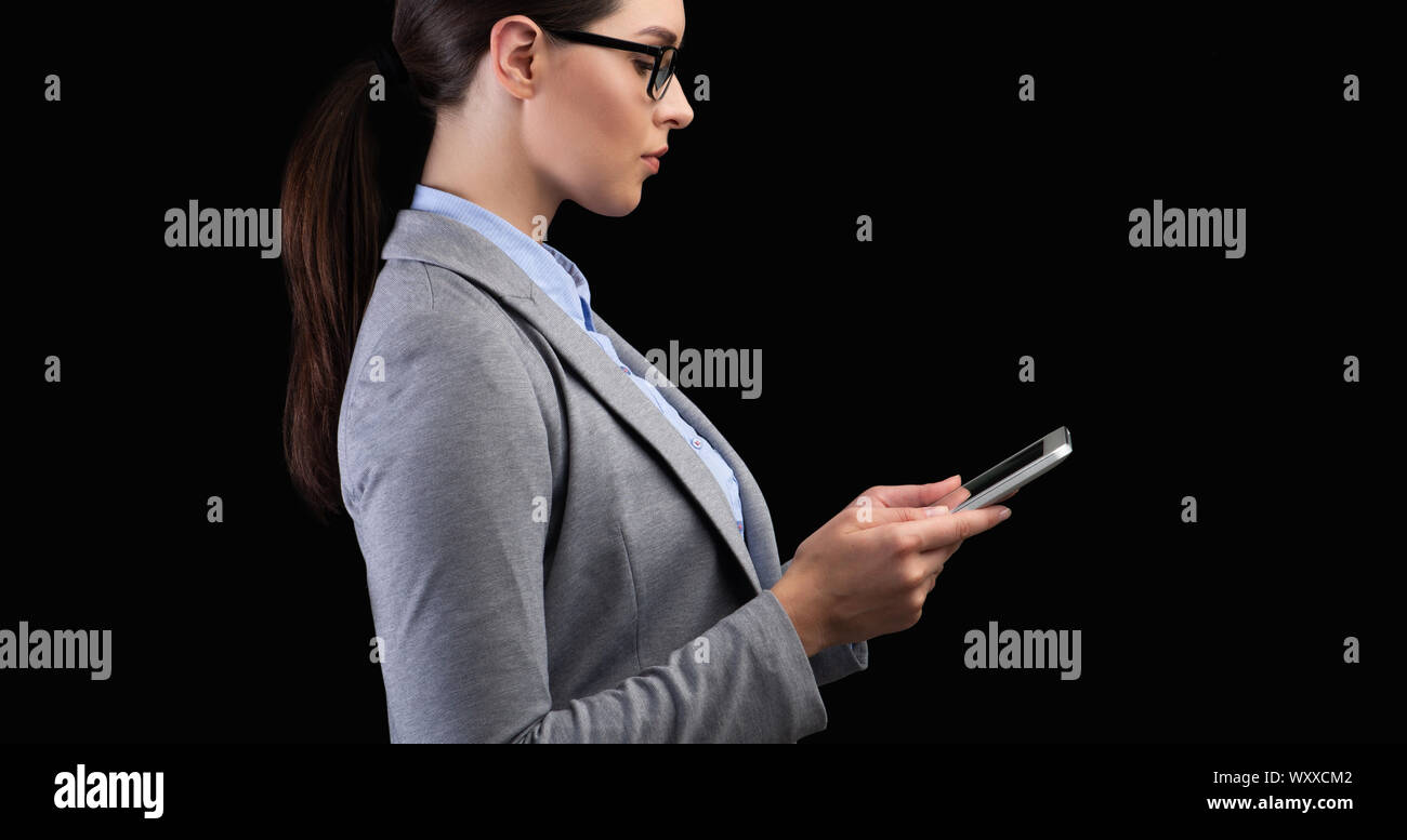 Geschäftsfrau mit Handy scannen Gesicht im Studio Stockfoto