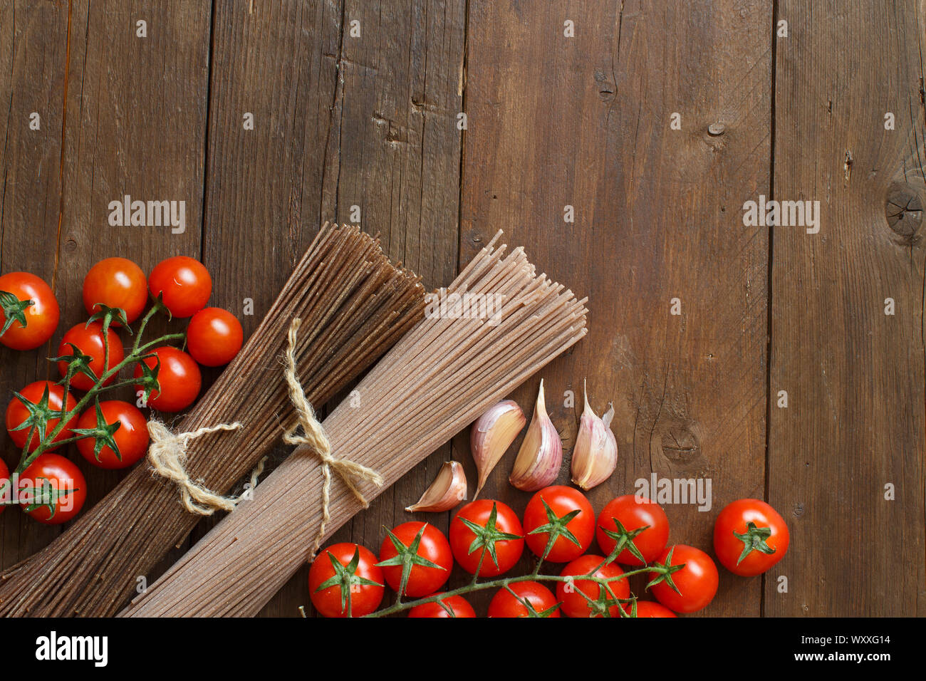 Zwei Arten von Spaghetti, Tomaten und Knoblauch auf Holz Stockfoto