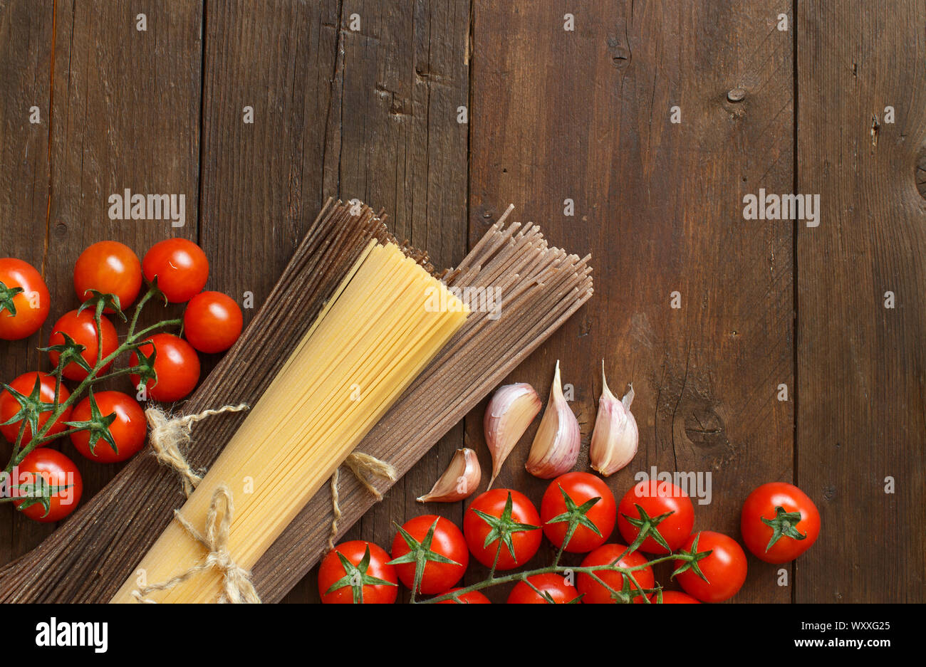 Drei Arten von Spaghetti, Tomaten und Knoblauch auf Holz Stockfoto