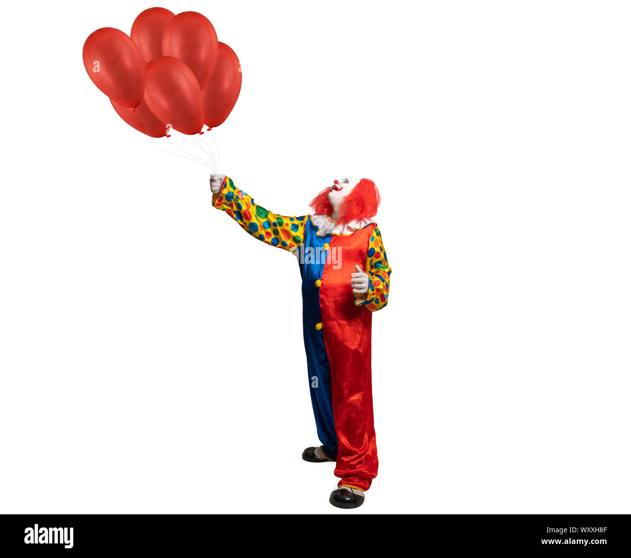 Ein Clown hält rote Ballons in der Hand Stockfoto