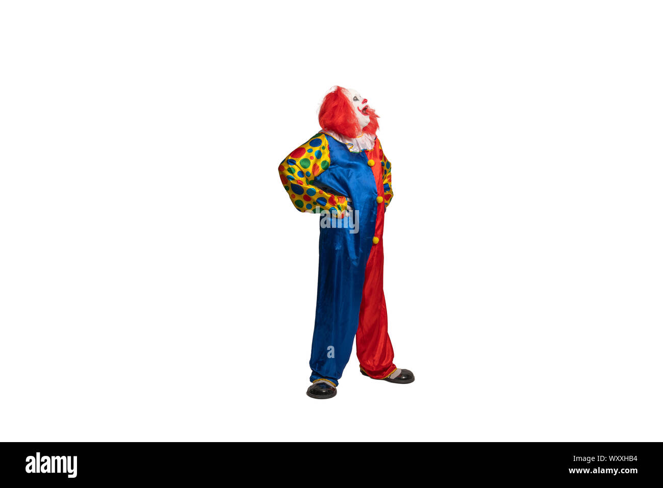 Lustige Clown mit Kostüm und Make-up sieht an der Seite Stockfoto