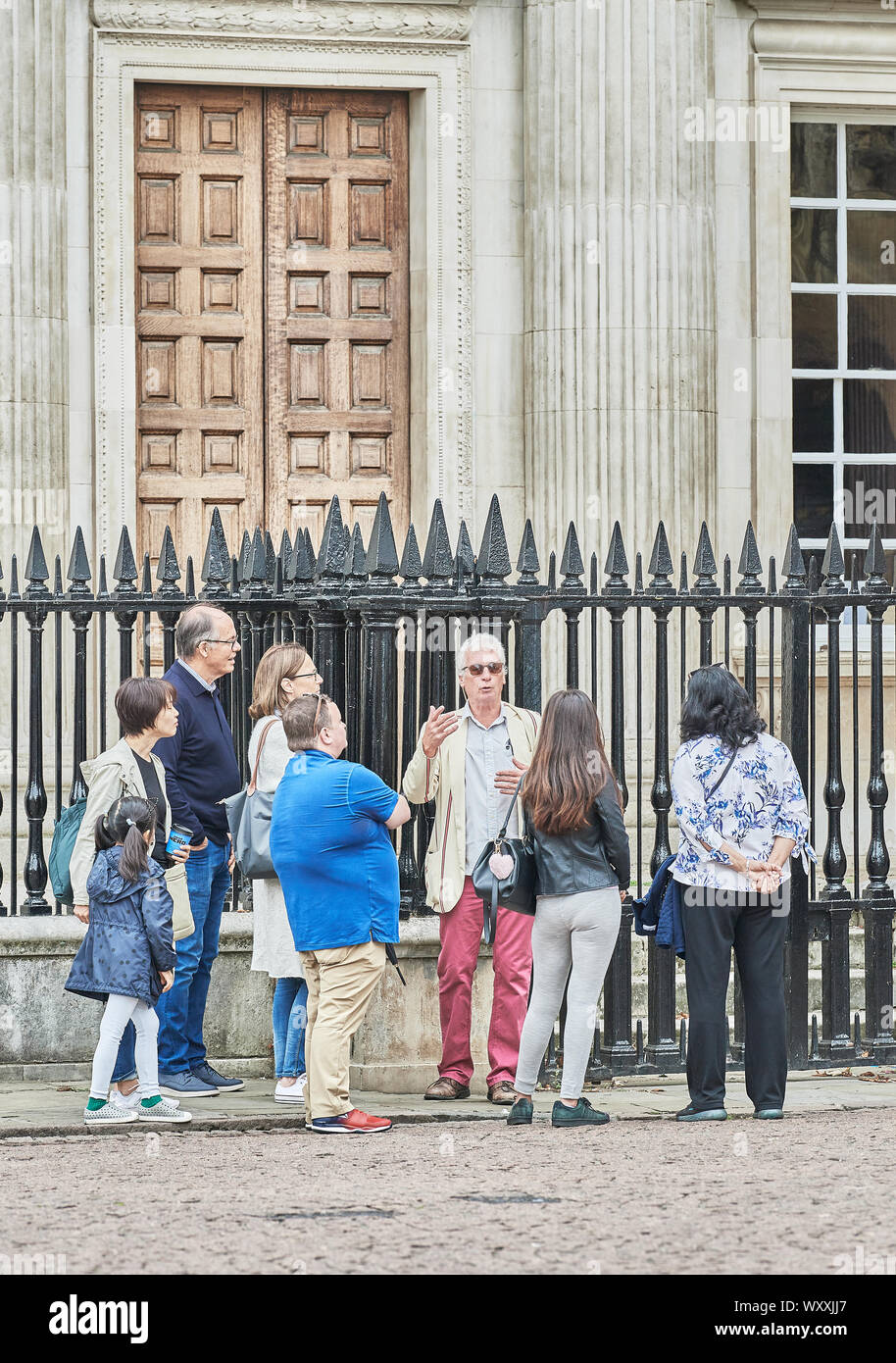 Eine Gruppe von Touristen mit ihrem Guide außerhalb Senat Haus, Universität Cambridge, England. Stockfoto