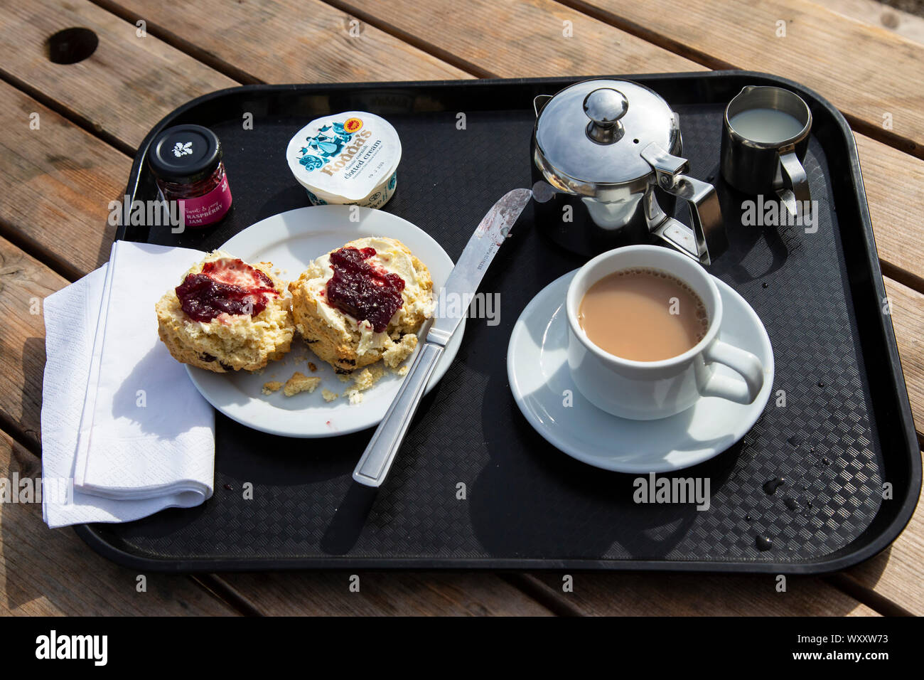 Ein sehr englischer Nachmittagstee serviert mit Scone, clotted cream und Erdbeere oder Himbeere Marmelade mit langjähriger Streitigkeiten über Marmelade oder Creme erste Stockfoto