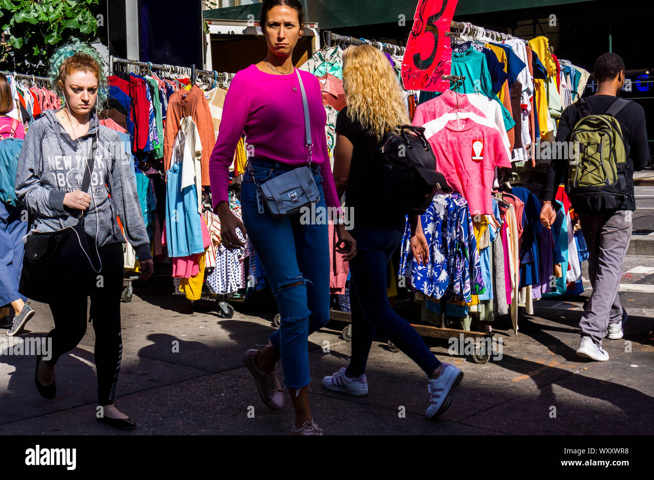 Menschen gehen vorbei an einem Straßenhändler verkaufen chinesische und andere asiatische Bekleidung am Freitag hergestellt, 13. September 2019. (© Richard B. Levine) Stockfoto