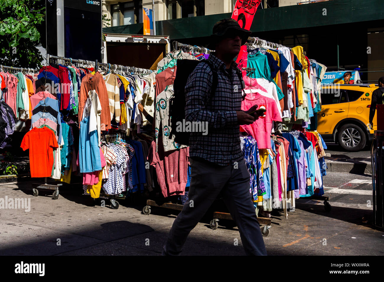 Menschen gehen vorbei an einem Straßenhändler verkaufen chinesische und andere asiatische Bekleidung am Freitag hergestellt, 13. September 2019. (© Richard B. Levine) Stockfoto