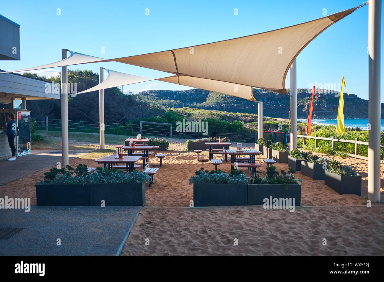 Ein Cafe im Palm Beach an einem sonnigen Tag mit einem klaren blauen Himmel in Richtung Barrenjoey Head suchen, New South Wales, Australien Stockfoto