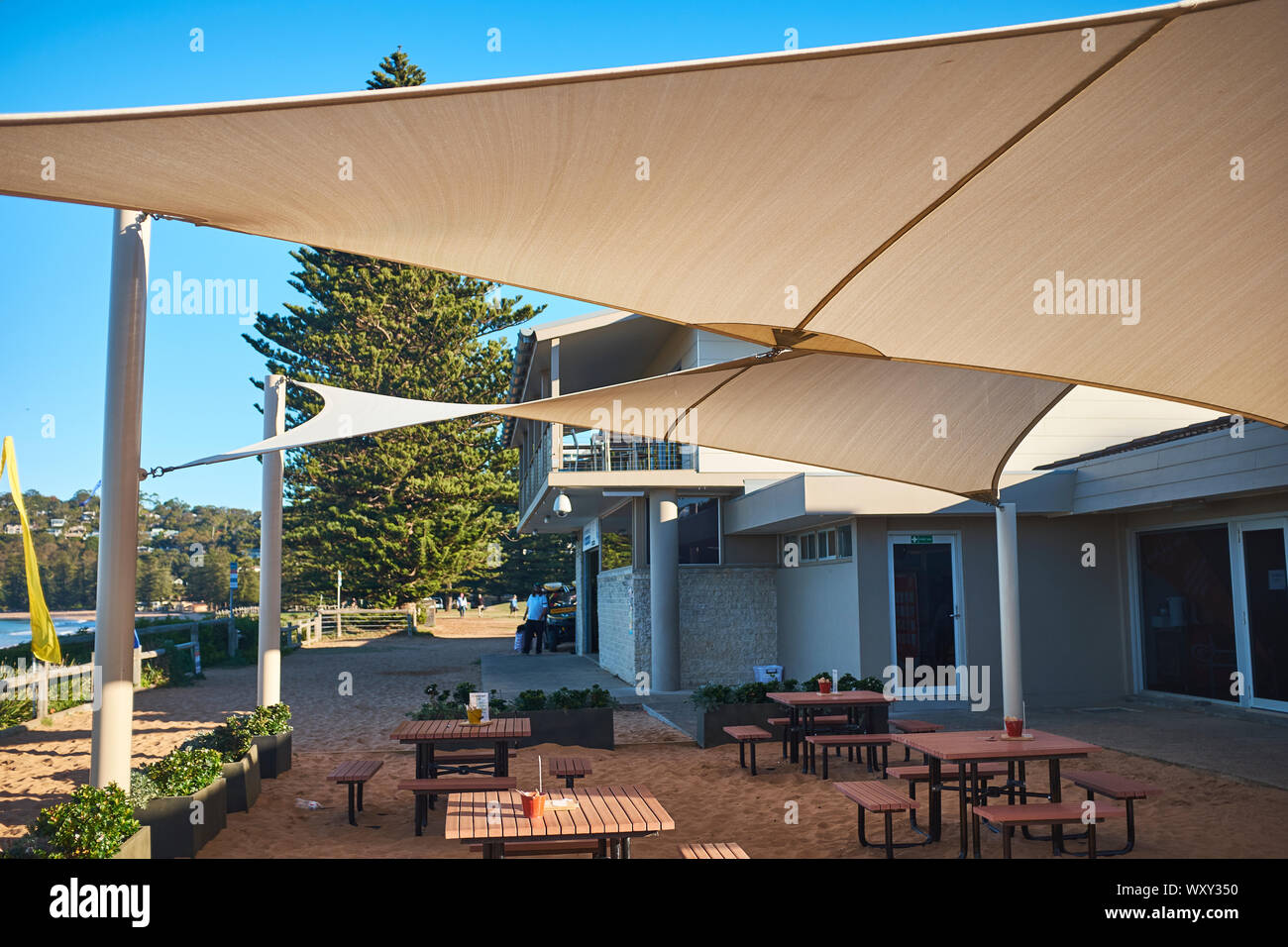 Ein Cafe im Palm Beach an einem sonnigen Tag mit einem klaren blauen Himmel in Richtung Barrenjoey Head suchen, New South Wales, Australien Stockfoto