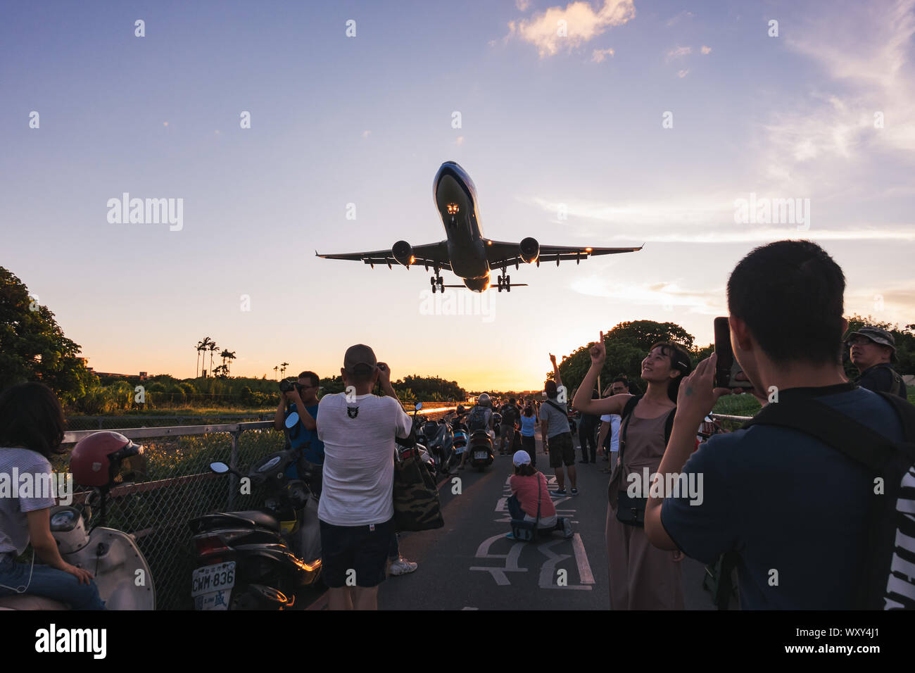 Zuschauer verfolgen und machen Sie Fotos wie ein Airbus A330-300 niedrig über den Köpfen der Ansatz von songshan Airport, Taipei fliegen Stockfoto