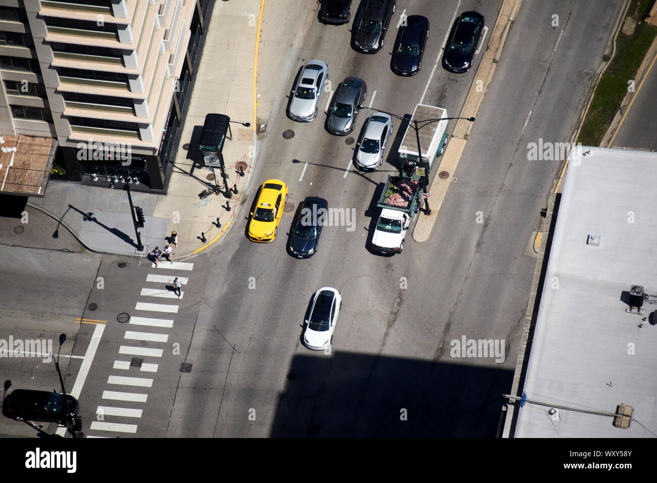 Ansicht von oben von Autos Anfahren aus Leuchten mit tesla Modell 3 ev Vor an der Kreuzung der Oak Street und North Michigan Avenue in Chicago illin Stockfoto