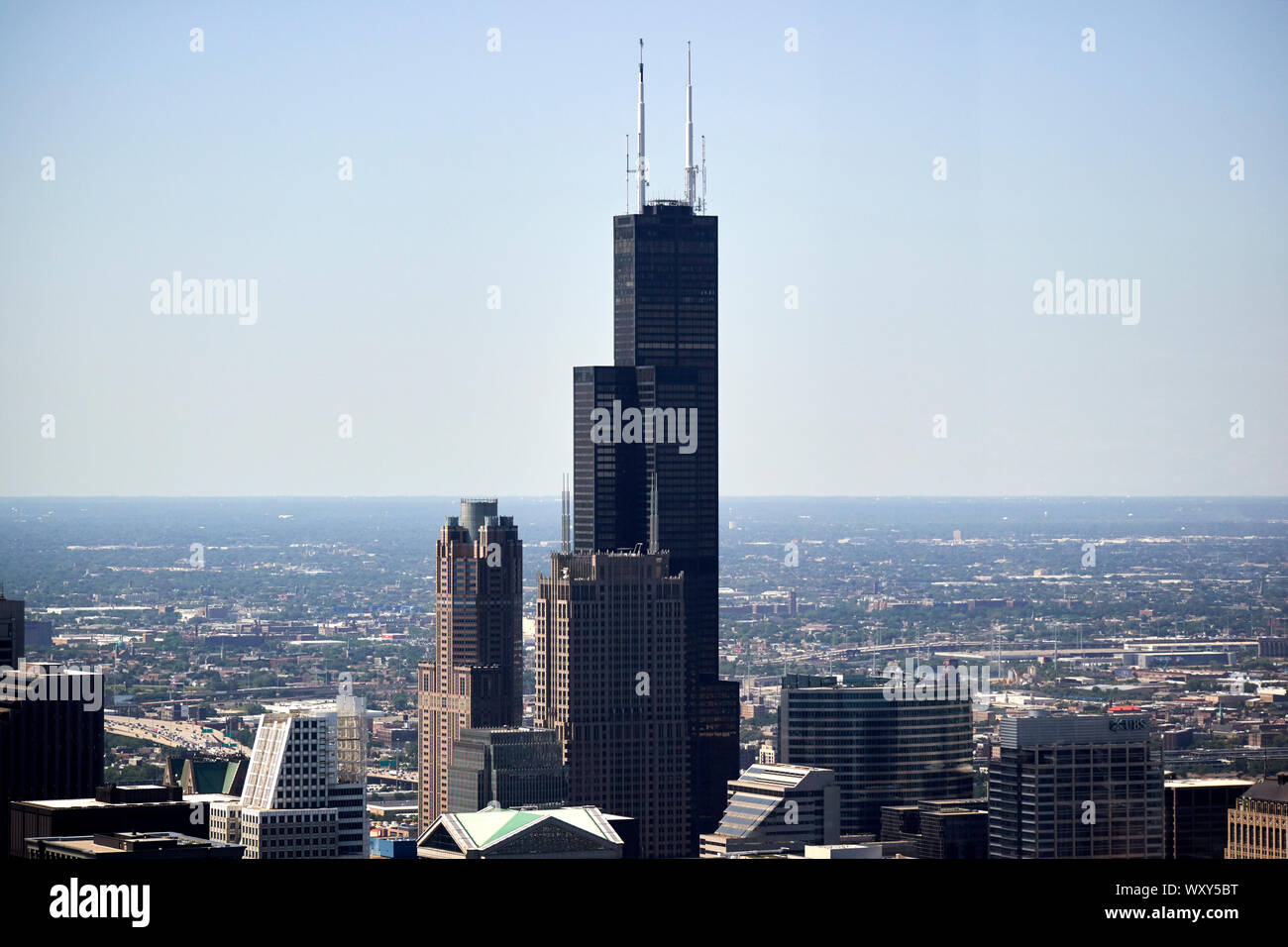 Die Oberseite der Willis Sears Tower und den umliegenden Gebäuden, die auf den Horizont schauen, wie durch Glas aus dem Hancock Center Chicago Illinois gesehen Stockfoto