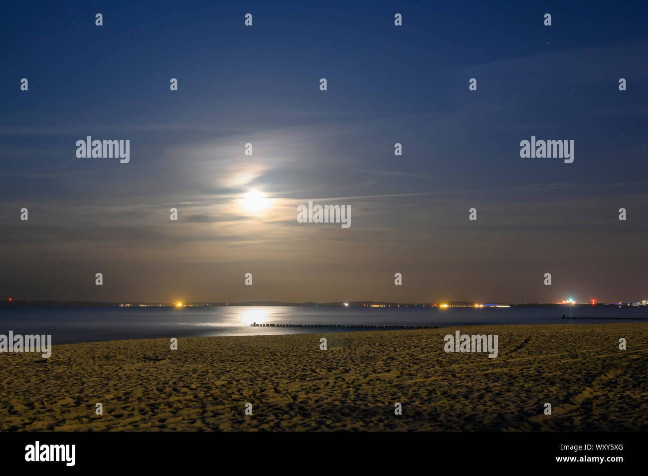 Mondaufgang am Meer von Usedom, Deutschland. Im Dunst am Horizont sehen die Lichter an der polnischen Küste. Stockfoto