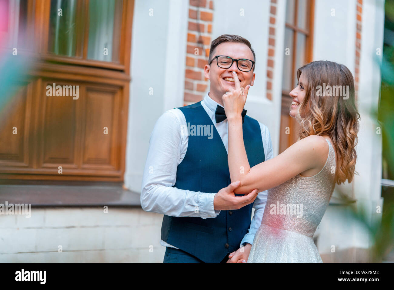 Frisch vermählte Paar stehen eng zusammen, kuscheln und schmusen mit einem Lächeln. Sie alle sind glücklich über ihre Ehe. Stockfoto