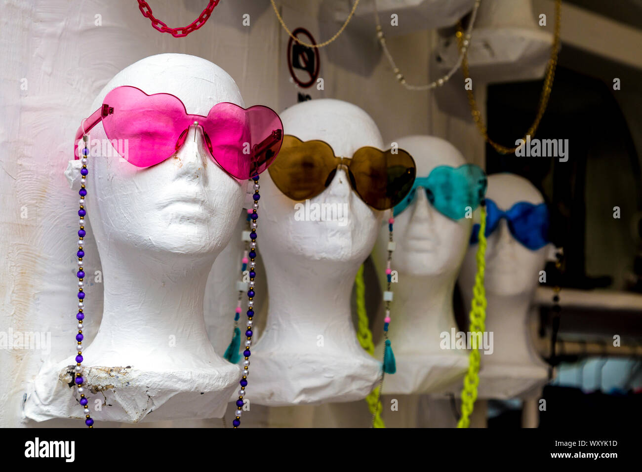 Souvenirshop, mannequin Köpfe tragen bunte herzförmige Sonnenbrillen in Dalt Vila, Ibiza, Spanien Stockfoto