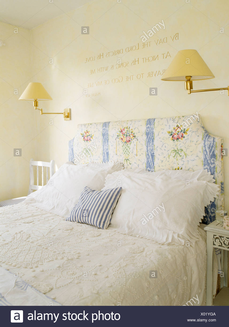 Floral Gemusterte Kopfteil Auf Bett Mit Spitze Bettdecke Und Kissen In Traditionellen Creme Landhaus Schlafzimmer Mit Wand Lampen Stockfotografie Alamy