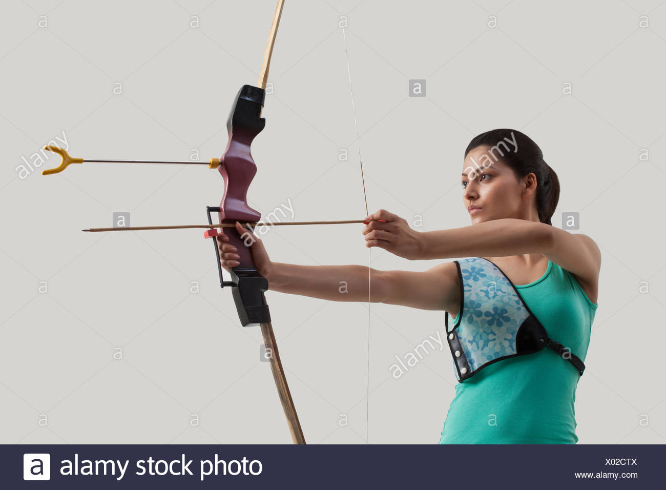Junge Weibliche Bogenschutze Mit Pfeil Und Bogen Gegen Grauen Hintergrund Stockfotografie Alamy