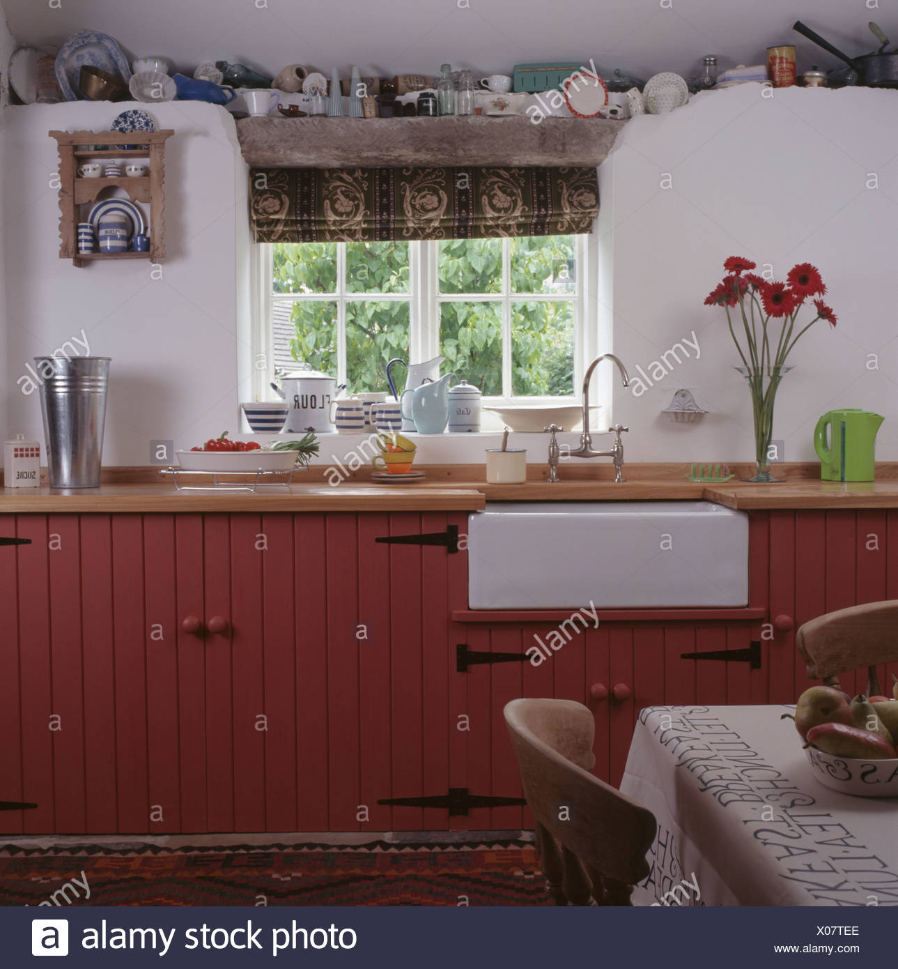 Weisse Belfast Waschbecken Unter Fenster In Weissen Cottage Kuche Mit Rosa Lackierten Einheiten Stockfotografie Alamy