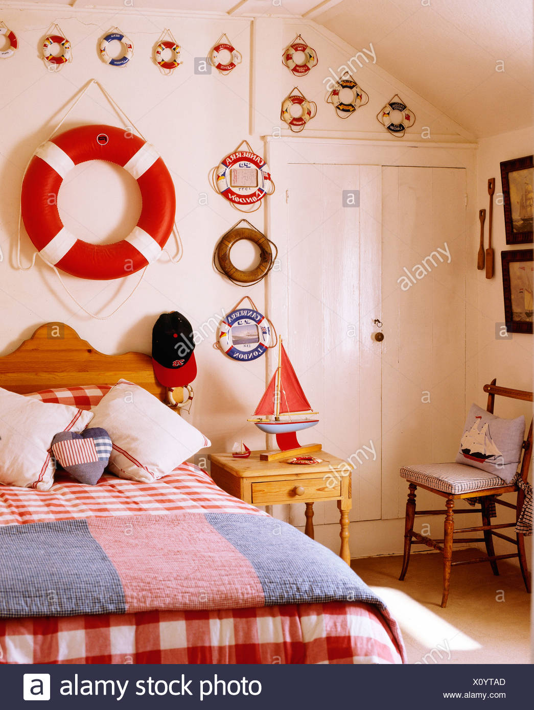 Rettungsring An Wand Uber Dem Bett Mit Roten Scheck Bettdecke Und Wolle Teppich Im Kinderzimmer Nautischen Themen Hutte Stockfotografie Alamy