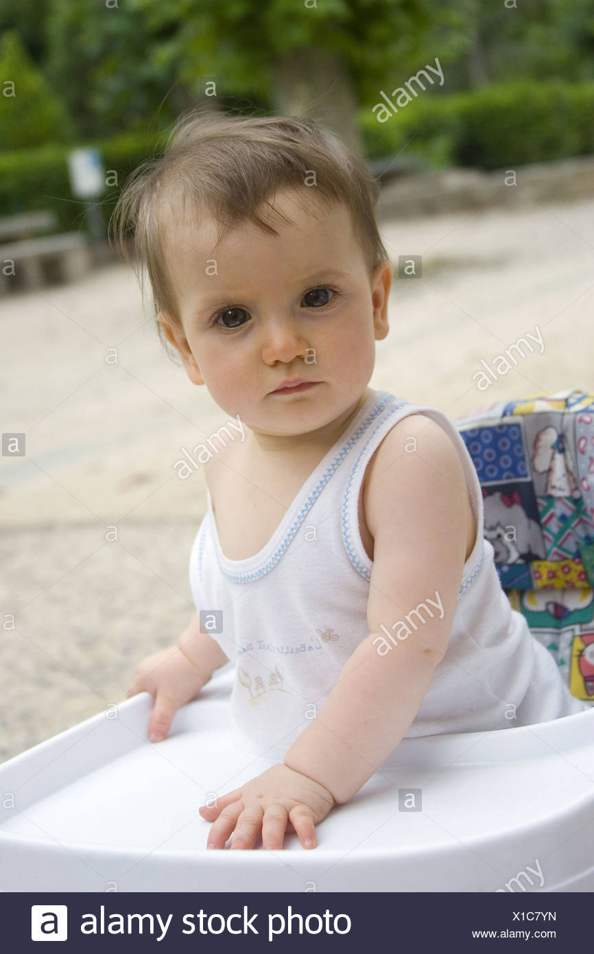 14 Monate Altes Baby Madchen Aussen Stehend In Einer Gehhilfe Blick In Die Kamera Mit Einem Ernsten Ausdruck Stockfotografie Alamy