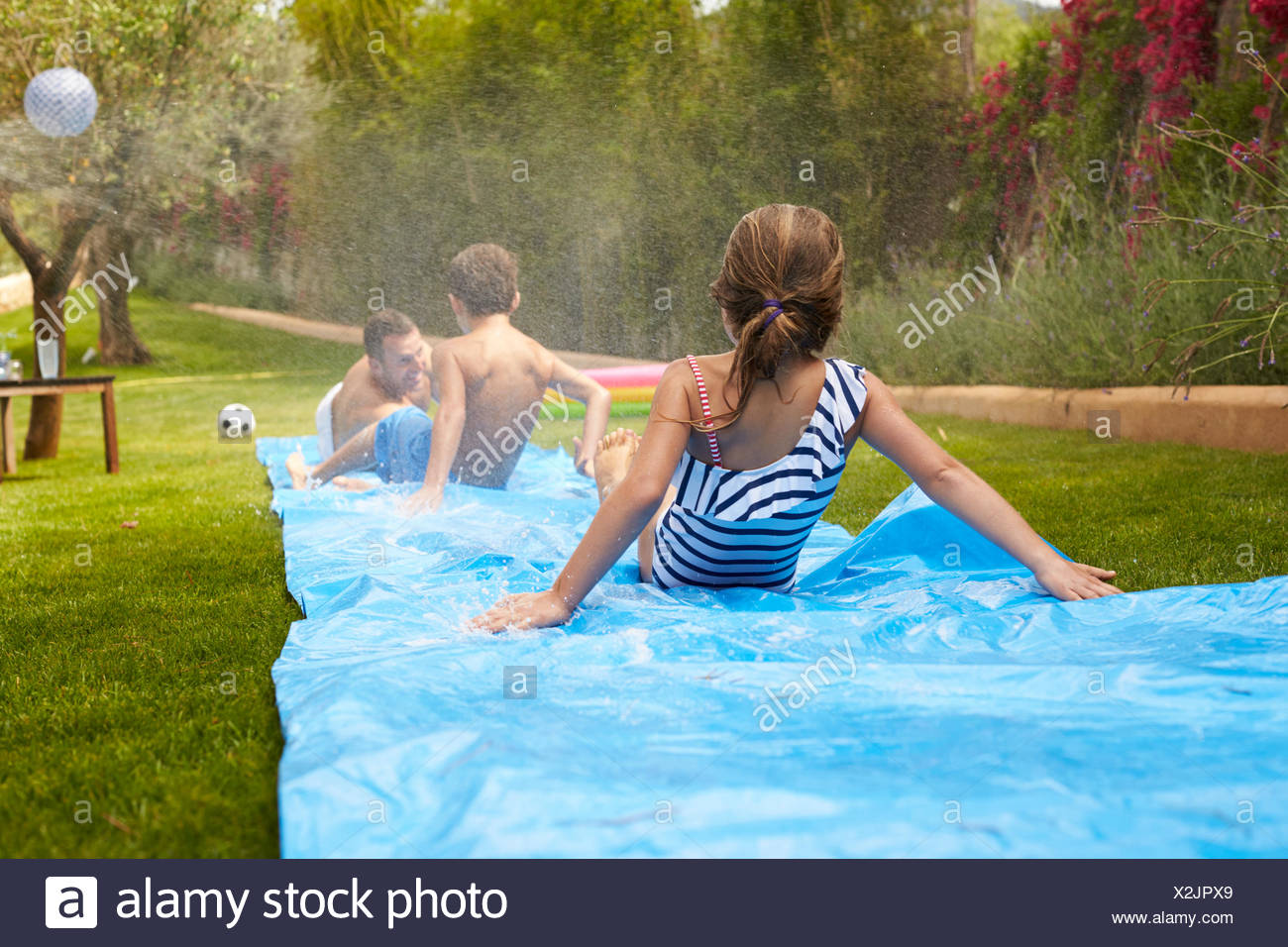 Ruckansicht Der Familie Spass Auf Der Wasserrutsche Im Garten