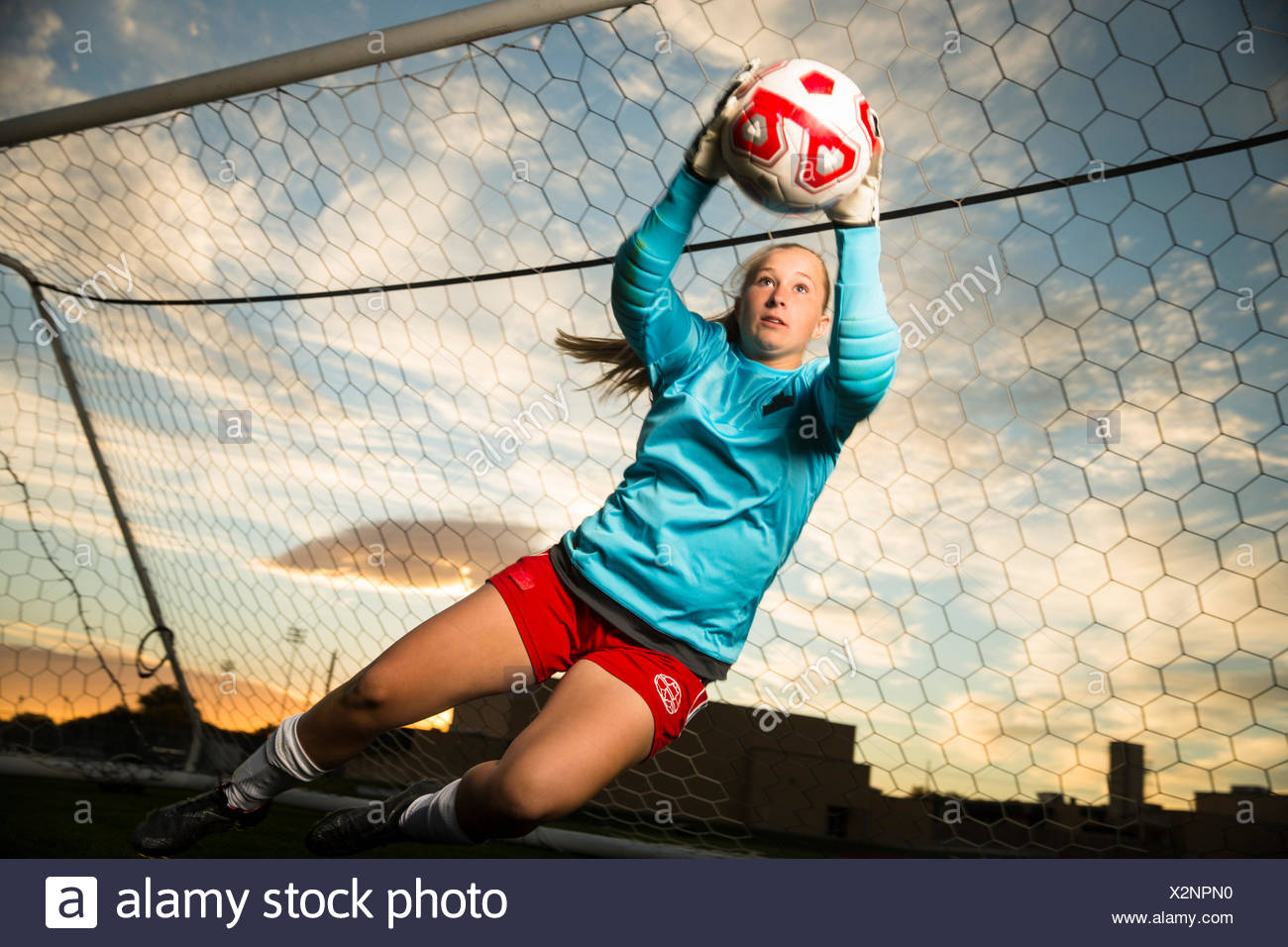 Niedrigen Winkel Blick Auf Torwart Springen Und Fangen Fussball Ball Im Tor Unter Blauem Himmel Stockfotografie Alamy