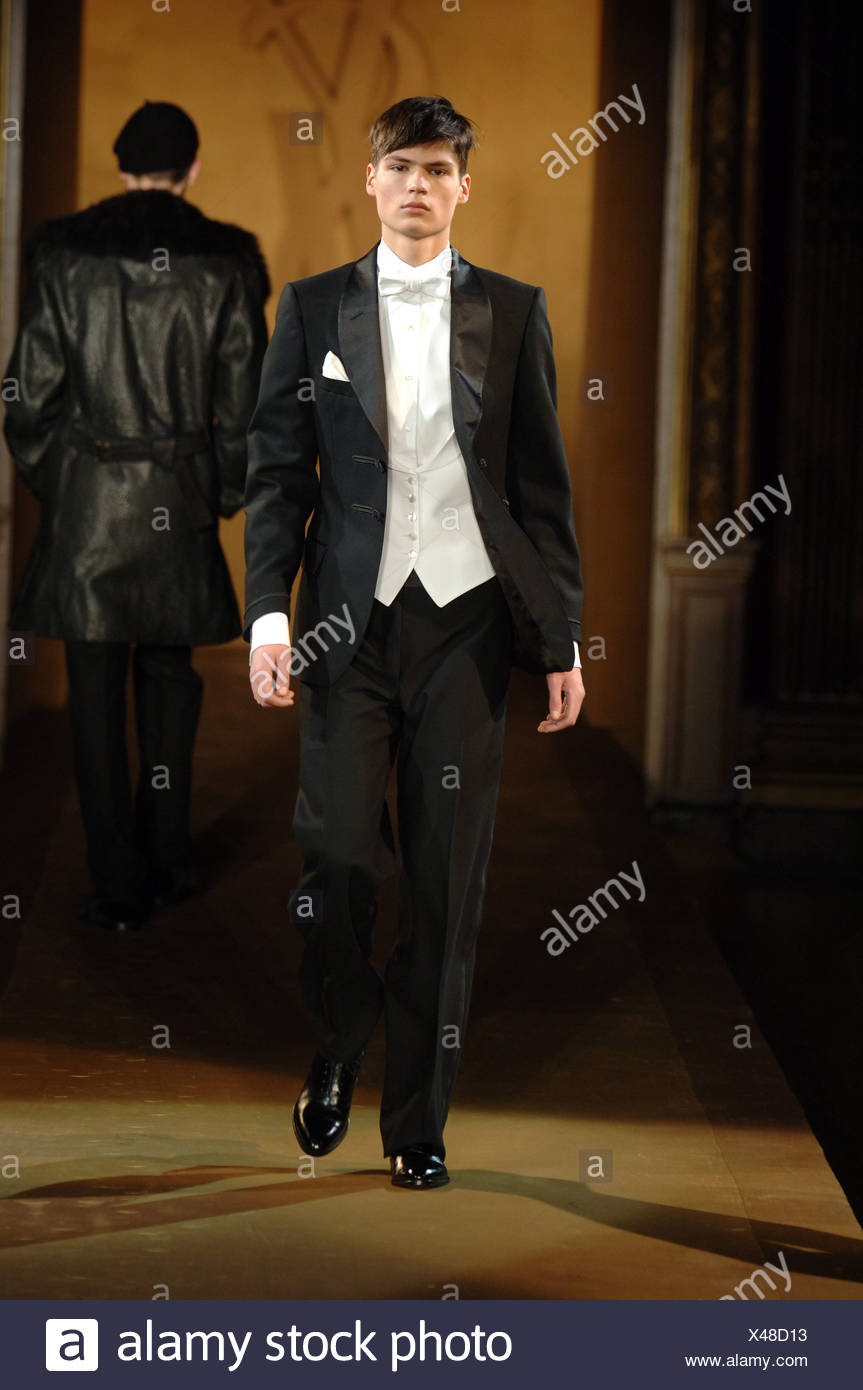 Brünette Männermodel trägt einen klassischen schwarzen Smoking mit weißer  Weste und Fliege Stockfotografie - Alamy