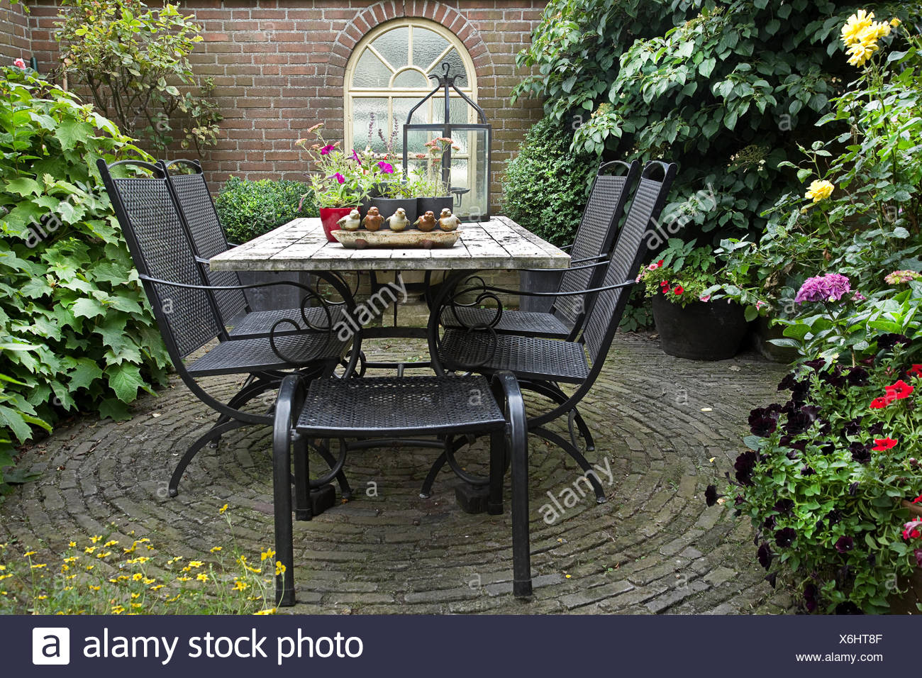 Geschmiedete Eisentisch Und Stuhle Im Garten Mit Blumen