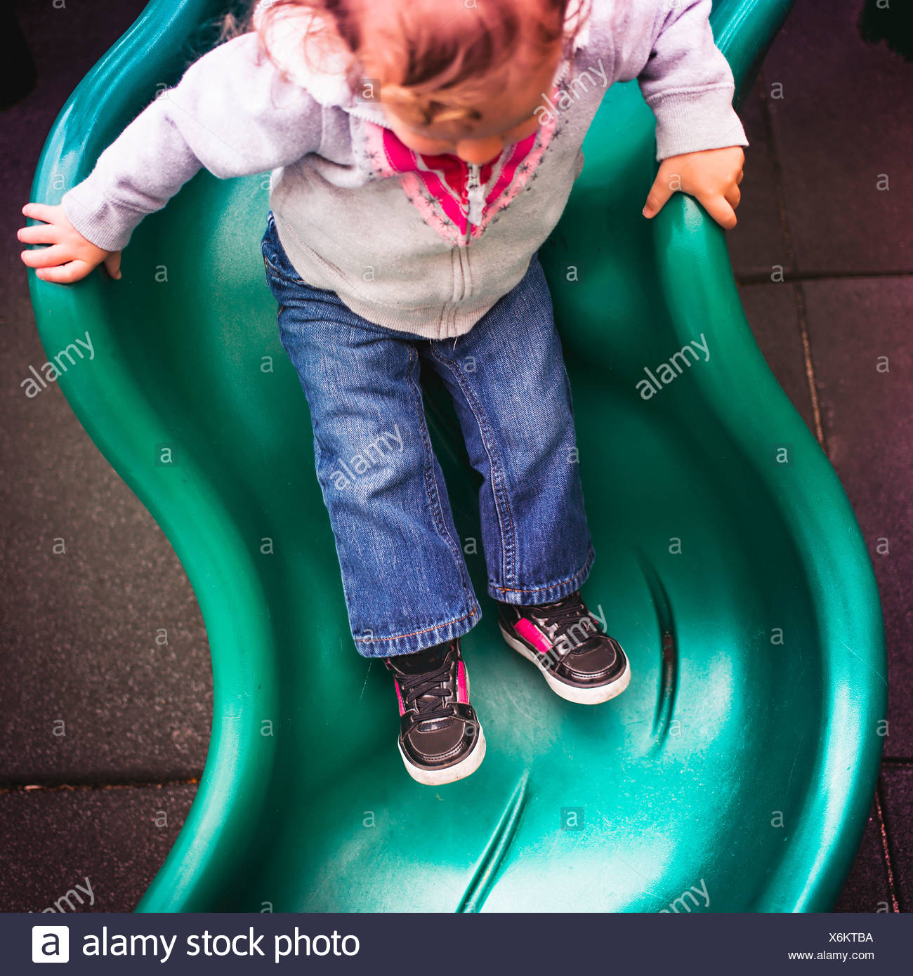 Kleinkind hinunter Folie auf Spielplatz Stockfoto