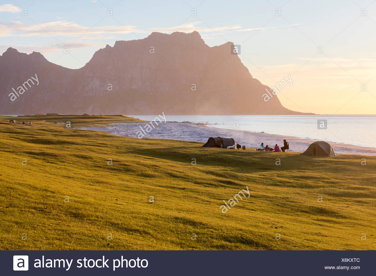 Camping Zelten auf grünen Wiesen neben Meer beleuchtet von Camping Zelten auf grünen Wiesen neben Meer beleuchtet von