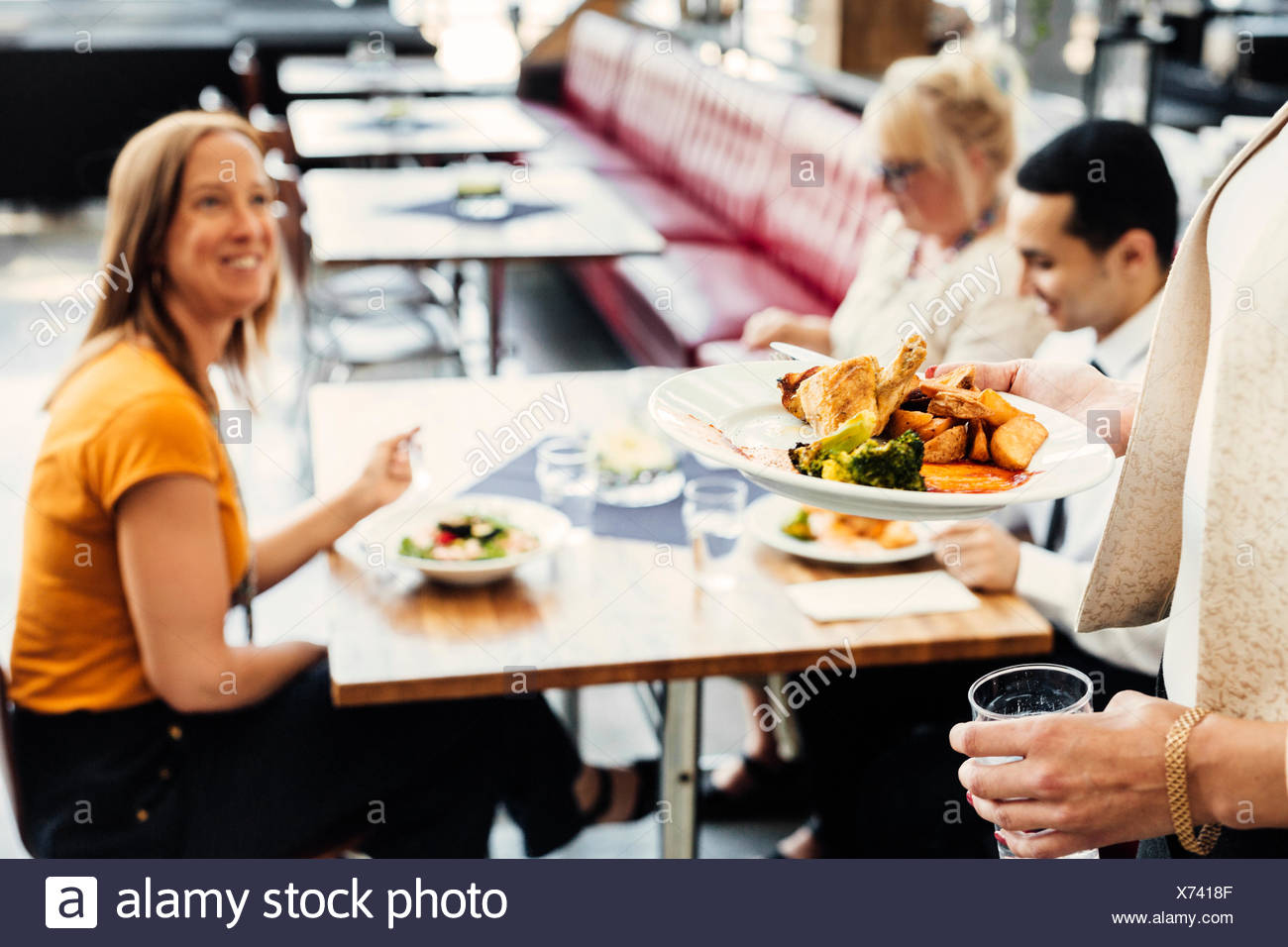Vier Kollegen treffen beim Mittagessen in der Cafeteria Stockfoto