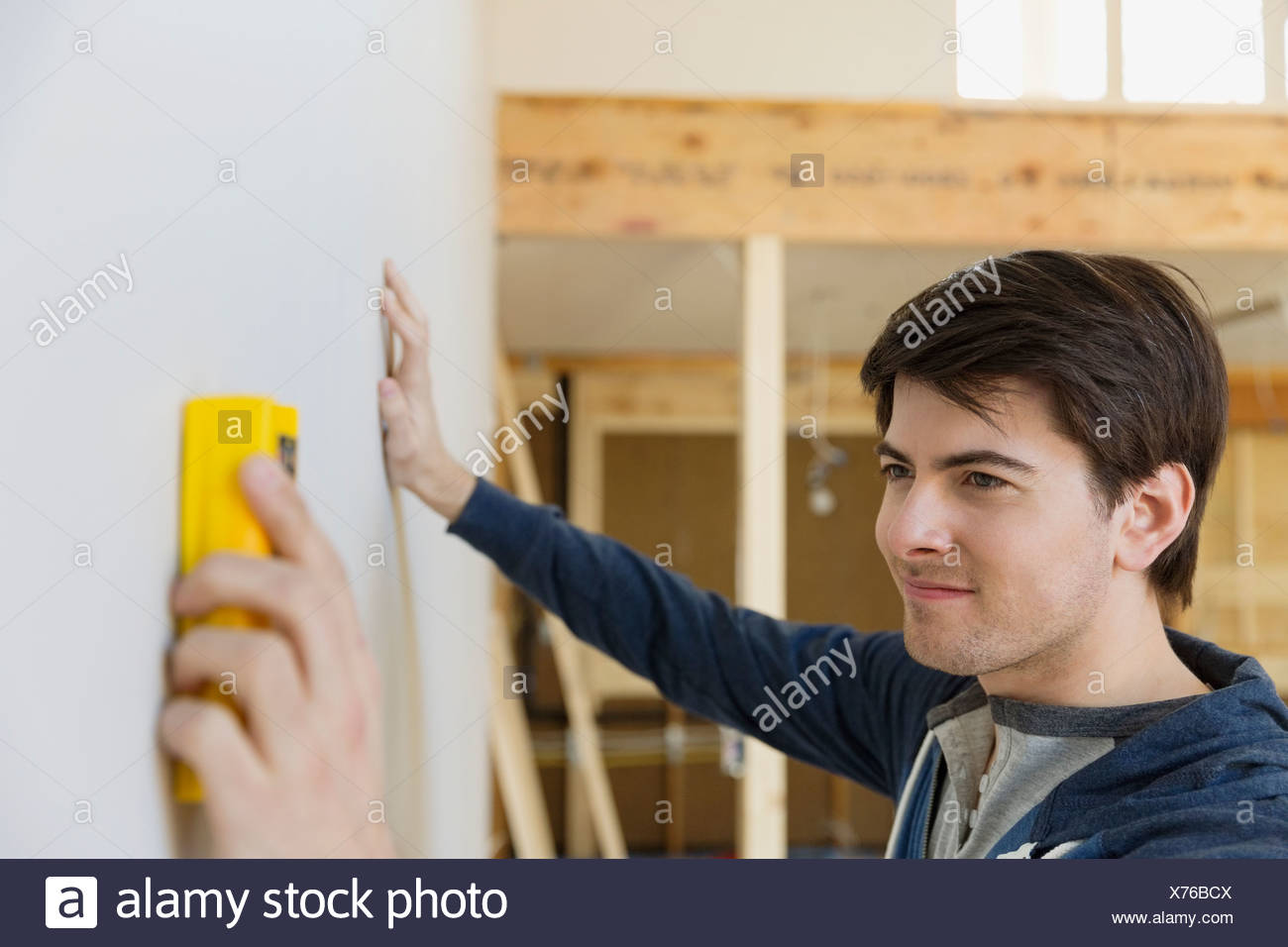 Junger Mann Mit Stud Finder Prufung Wand Zu Hause Stockfoto