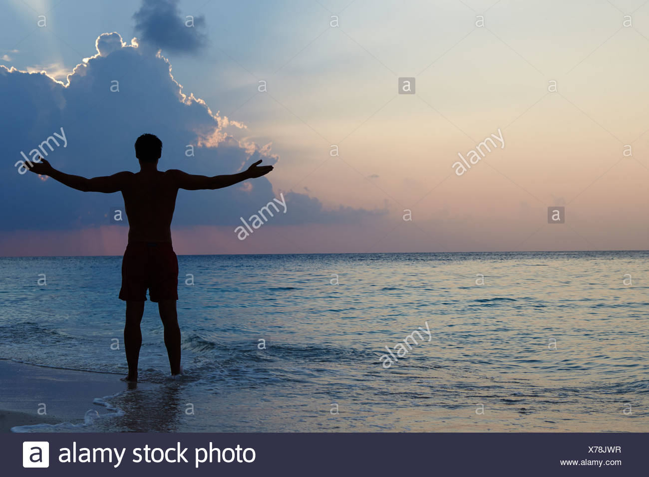 Silhouette Der Mann Mit Ausgestreckten Armen Am Strand Bei Sonnenuntergang Stockfotografie Alamy