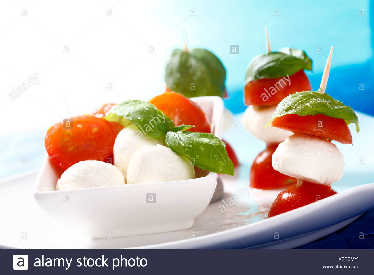 TomatenMozzarellasticks mit Basilikum auf einem Teller