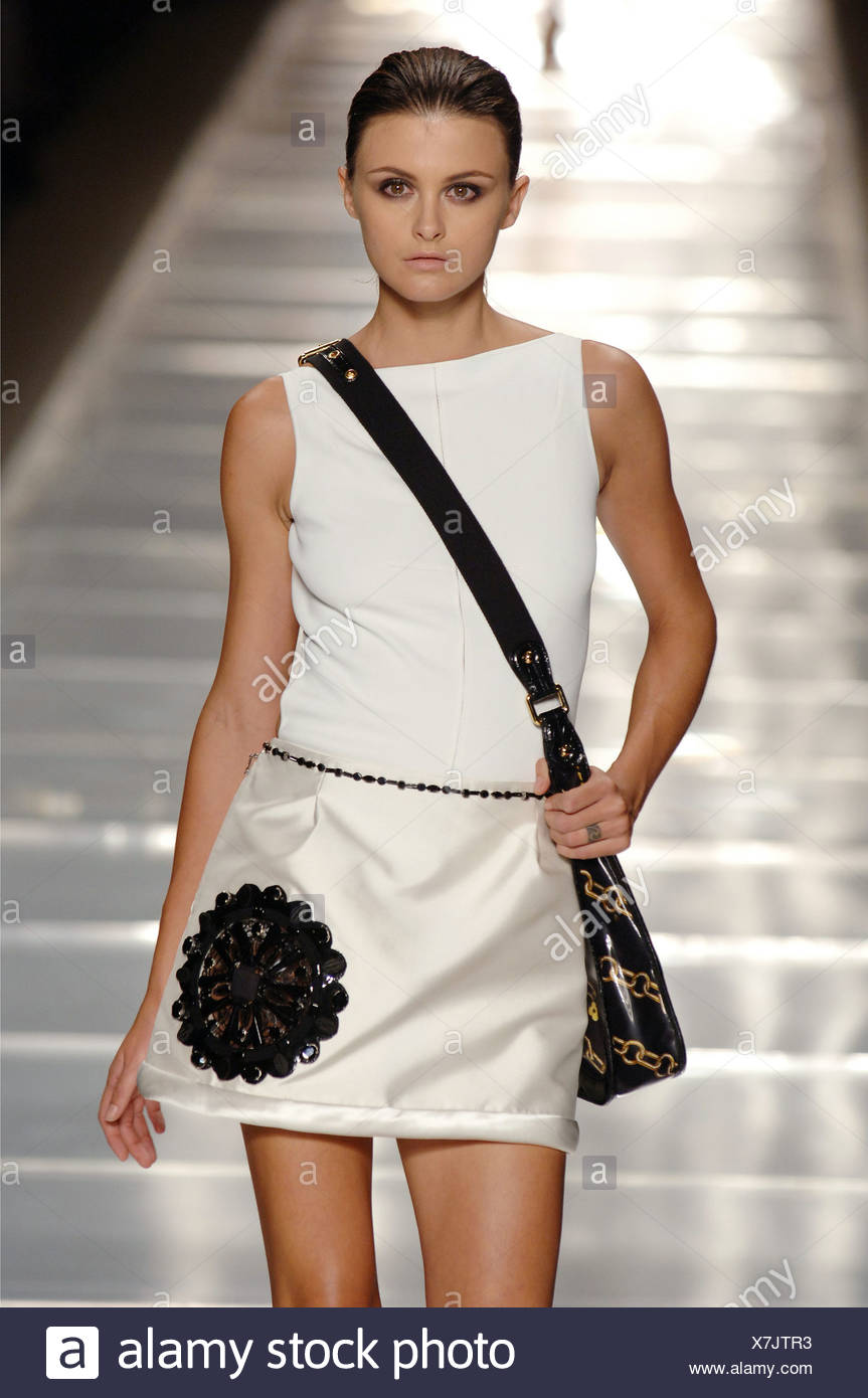 Weibliches Model Trish Goff Braune Haare Gezogen Rollte Zuruck Tragen Ein Weisses Armelloses Ausgestattetes Top Einen Kurzen Weissen Sild A Linie Rock An Stockfotografie Alamy