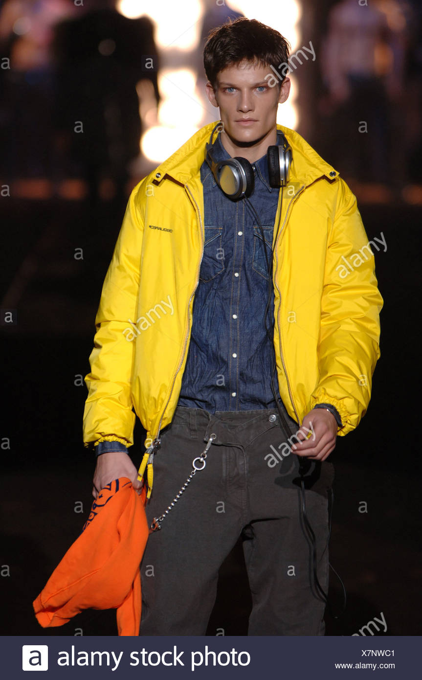 Mailand DSquared Menswear bereit zu tragen männliche kurze dunkle Haare  tragen Kopfhörer um Hals, blaues Jeanshemd unter leuchtend gelb  Stockfotografie - Alamy
