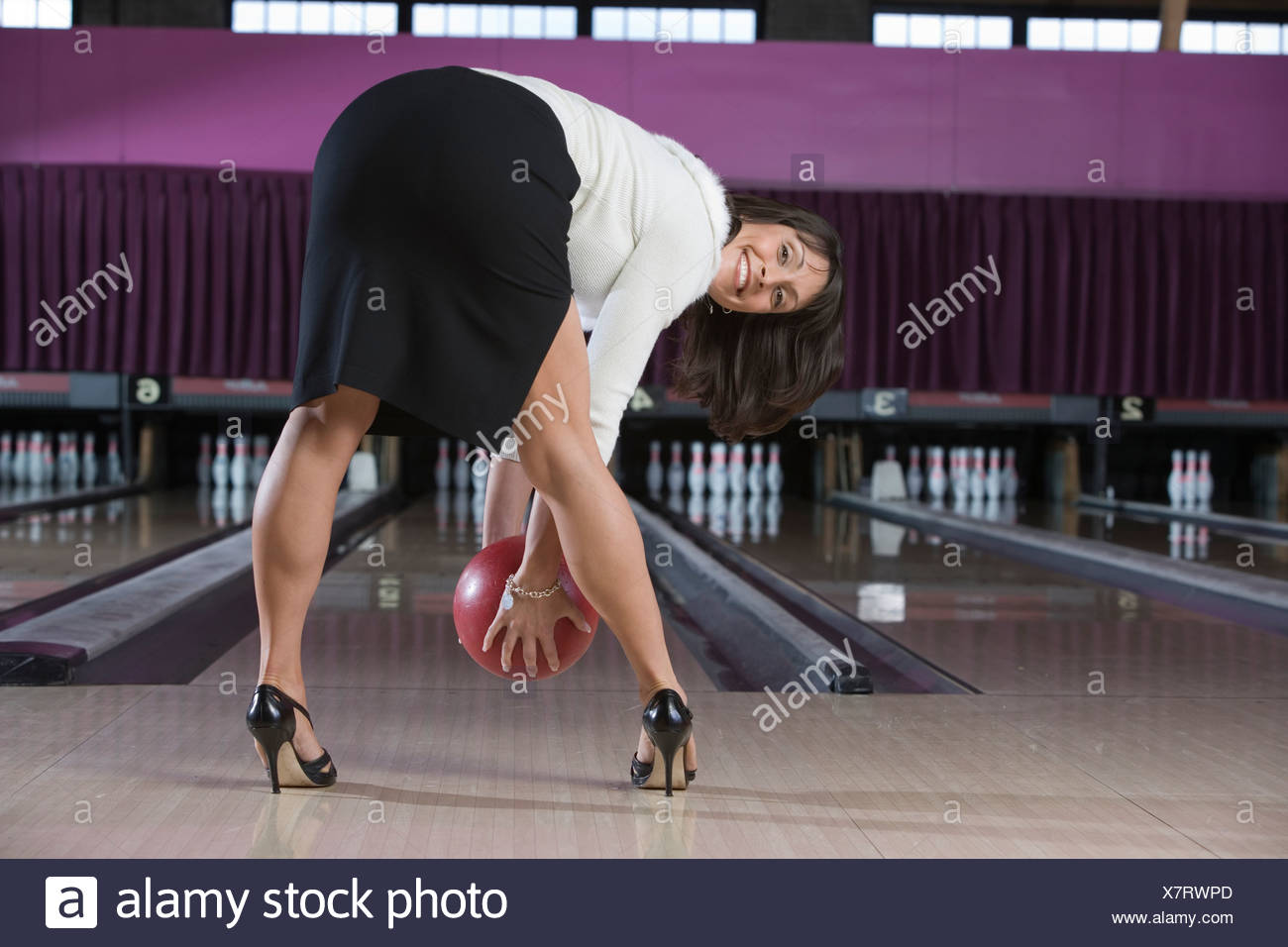 Womanin Highheels bücken mit Bowling Kugel Stockfoto, Bild Womanin Highheels bücken mit Bowling Kugel Stockfoto, Bild
