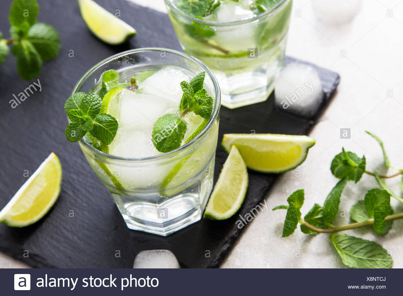 Kalte Limonade Erfrischende Sommer Mojito in einem Glas auf einer Schiefertafel Brett und Stein. Stockfoto