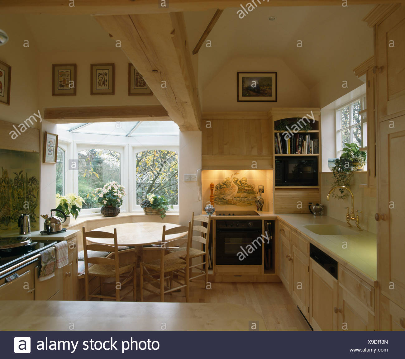 Ofen In Beleuchteten Nische In Landhauskuche Mit Runden Holztisch Im Fenster Des Kleinen Esszimmer Erweiterung Stockfotografie Alamy