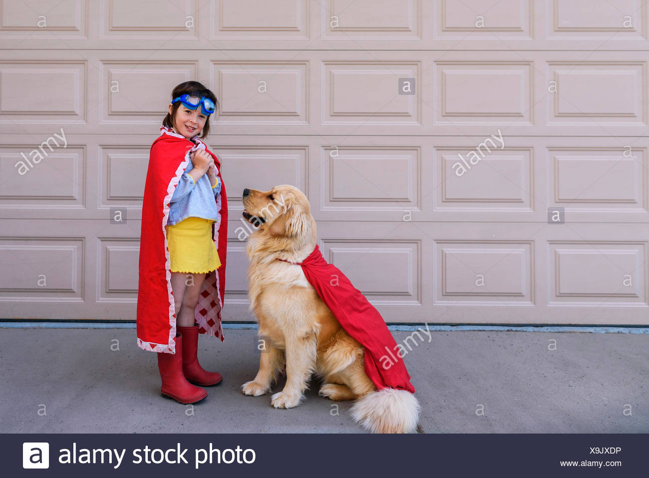 Madchen Gekleidet Wie Ein Superheld Durch Die Garage Mit Ihrem Golden Retriever Hund Stockfotografie Alamy
