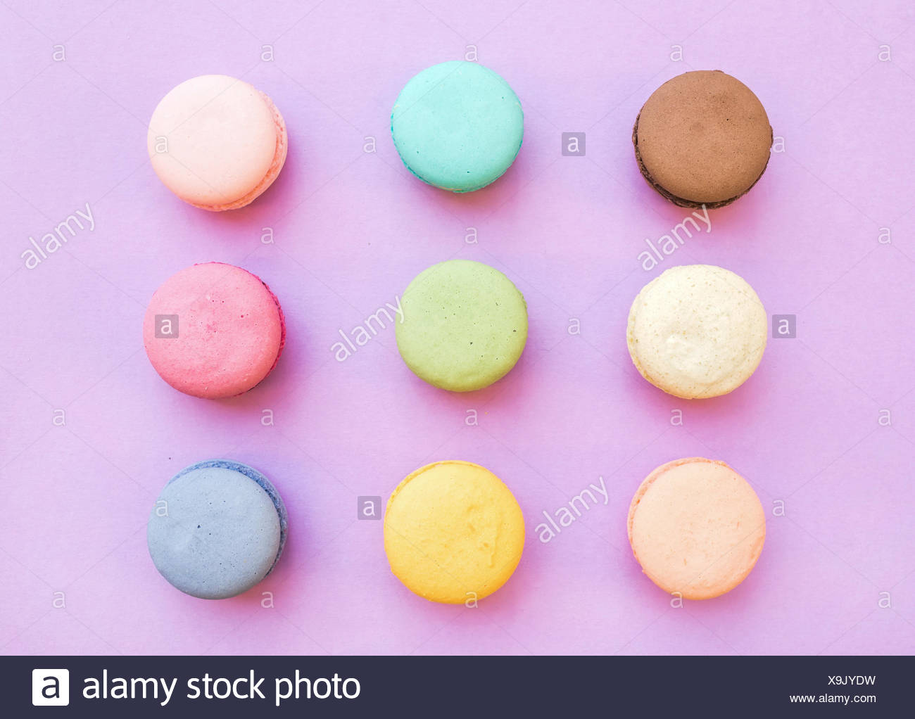 Süße bunte französische Macaron Kekse auf Pastell rosa Hintergrund, Ansicht von oben Stockfoto