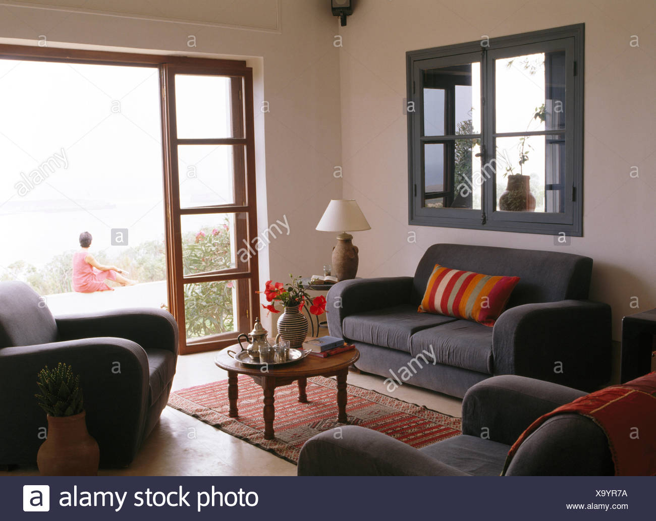 Grauen Sofa Unter Internen Fenster Im Marokkanischen Wohnzimmer Mit Blick Durch Glasturen Frau Sitzt Auf Hof Stockfotografie Alamy