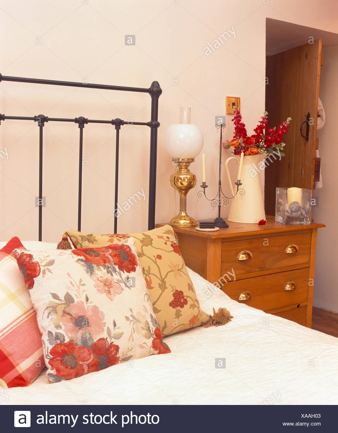 Viktorianischen Glaslampe Auf Dem Nachttisch Neben Eisen Bett Ith Florale Kissen Stockfotografie Alamy