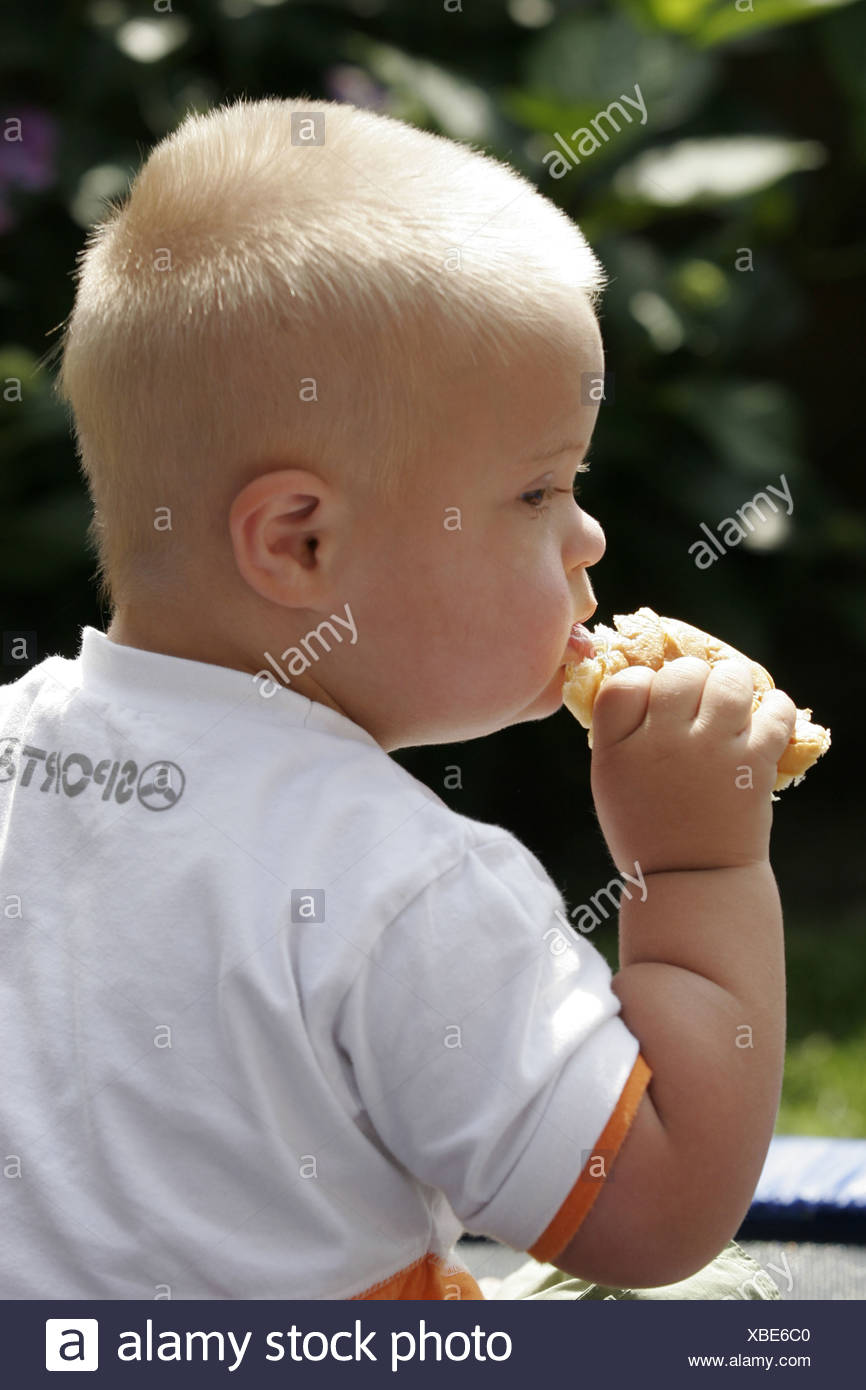 Down Syndrom Baby Junge Mit Brot In Einer Hand Essen Seite Ansicht Erbkrankheit Kind Stockfotografie Alamy