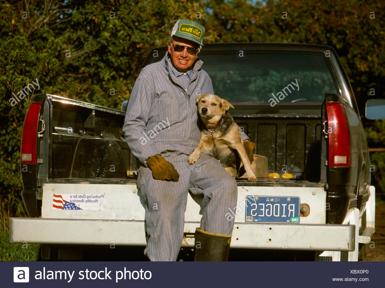 Landwirtschaft Ein Bauer In Overalls Sitzt Auf Der Heckklappe Seines Pickup Trucks Mit Seinem Hund Iowa Usa Stockfotografie Alamy