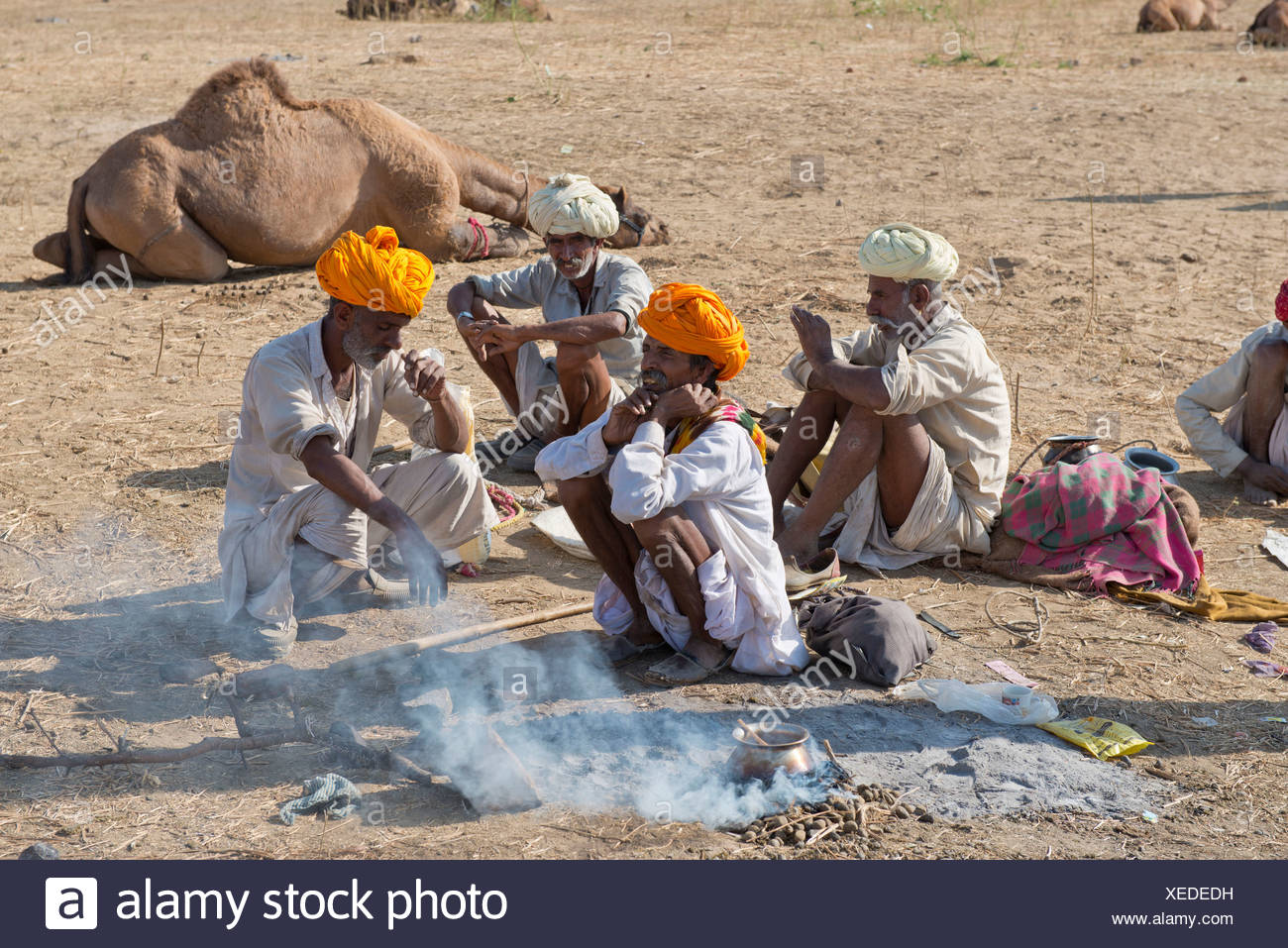 Vier Altere Indische Manner Mit Turbanen Und Tragen Das Traditionelle Dhoti Kleidungsstuck Auf Dem Boden Hocken Ist Essen Zubereitet Wird Stockfotografie Alamy