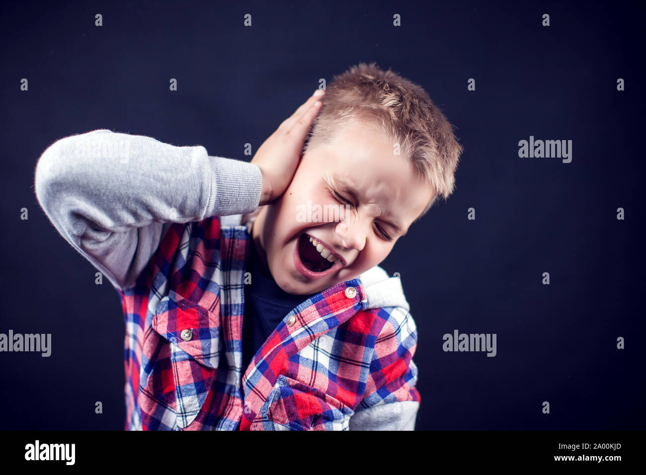 Un niño se siente fuerte dolor de oído. Los niños, asistencia sanitaria y medicina concepto Foto de stock