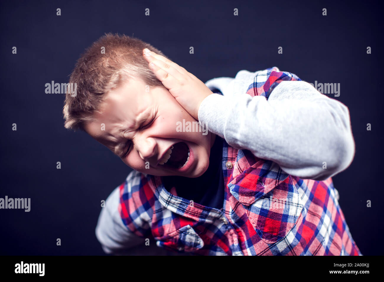 Un niño se siente fuerte dolor de oído. Los niños, asistencia sanitaria y medicina concepto Foto de stock