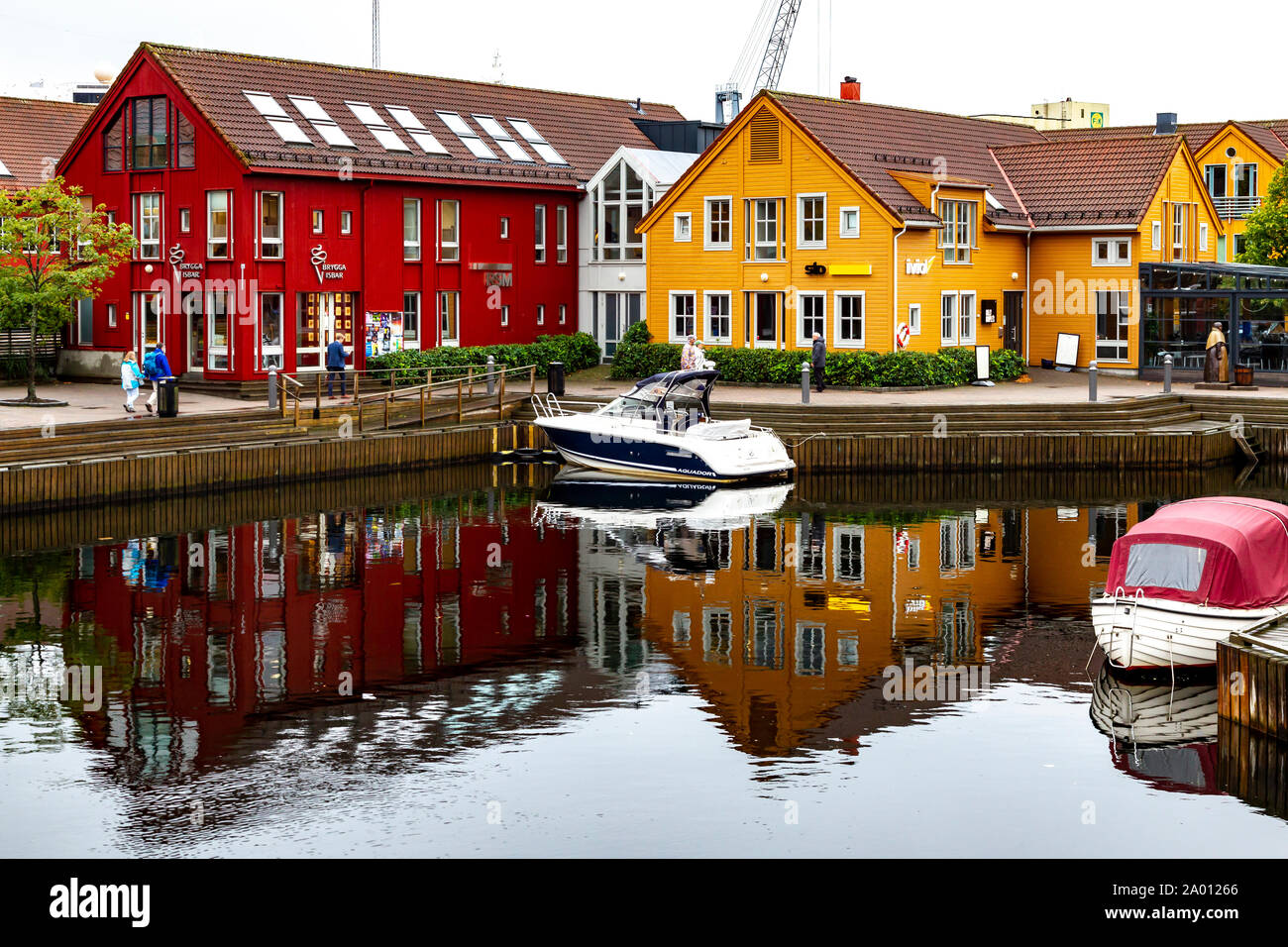 Muelle de pescadores, con reflejo de los edificios de madera en el agua tranquila, Kristiansand, Noruega. Foto de stock