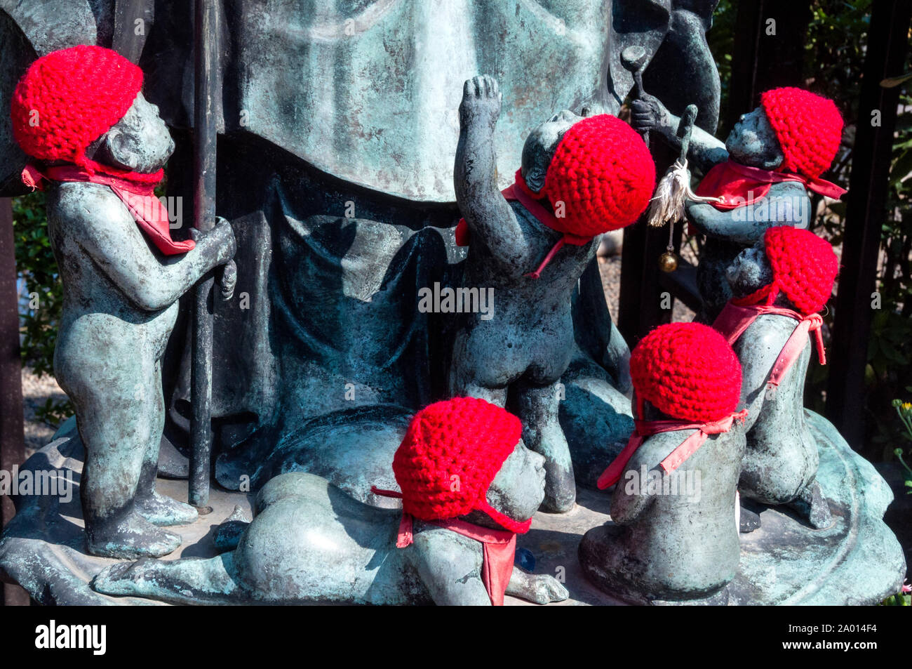 Tejido de sombreros rojos son conmovedores los regalos de los padres colocan en Jizu estatuas en honor a los niños por nacer, en Tokio, Japón. Foto de stock
