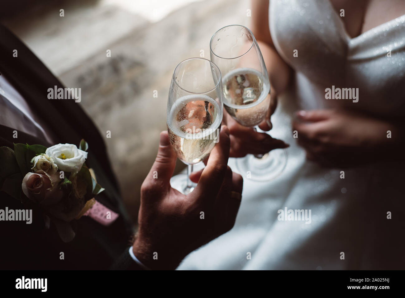 Cerca de pareja casada tostado copas de champaña en la fiesta de bodas. Manos vasos tintineo para el novio y la novia en la recepción de la boda. Foto de stock