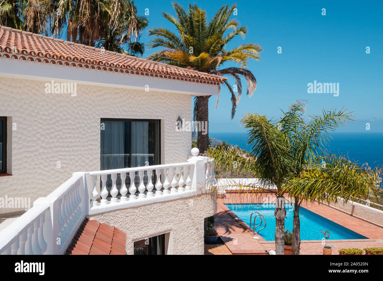 Casa con piscina, palmeras y del mar vista al mar Foto de stock